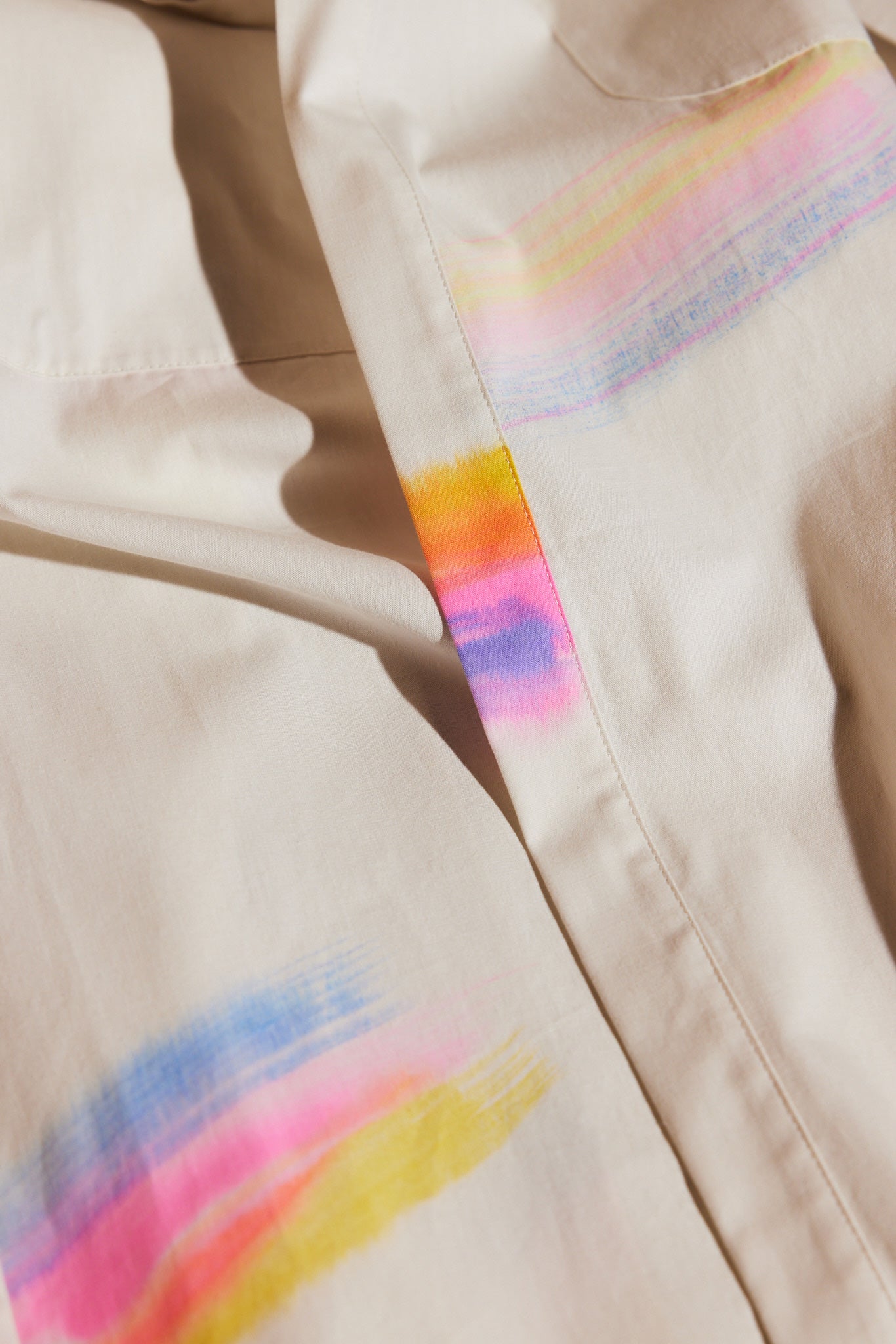 detail of off-white cotton robe with rainbow print